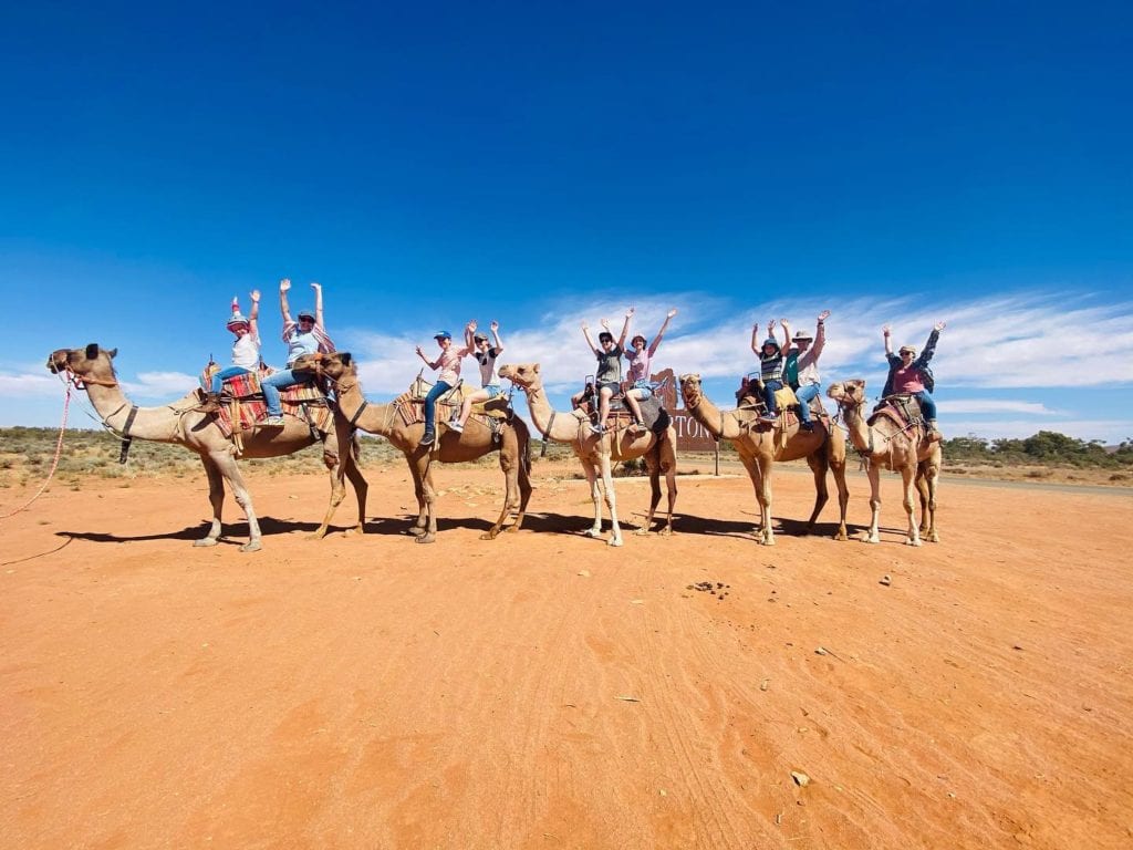 Happy people enjoying a camel ride in Silverton